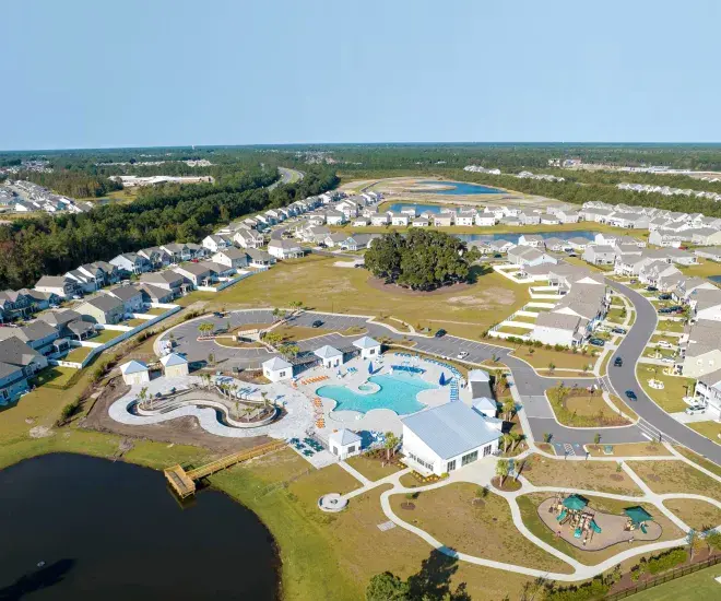 Aerial view of a residential community with homes, pools, walking paths, and ponds